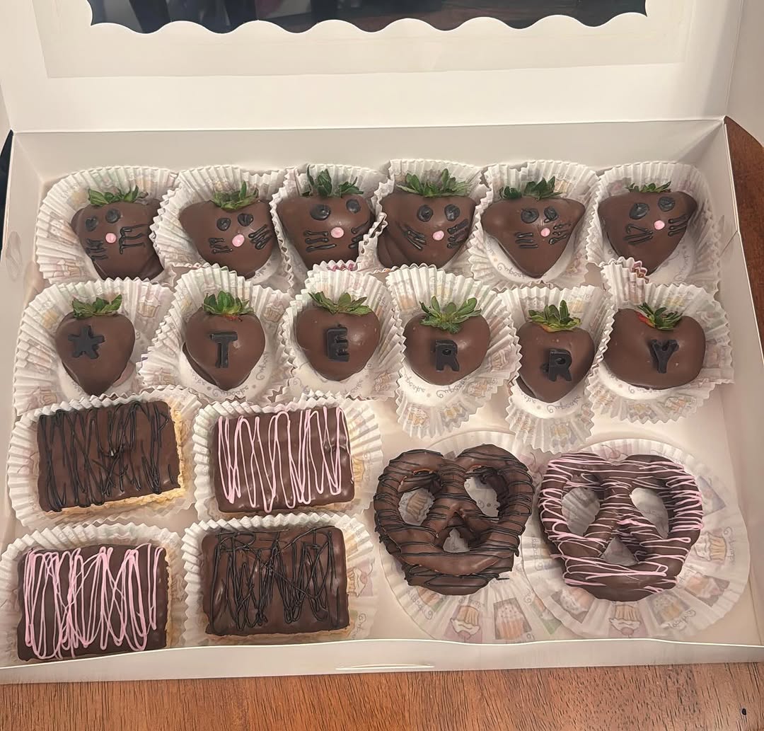 Personalized gift box with cat-face strawberries, name TERRY spelled in chocolate letters across five berries, plus drizzled treats and pretzels.