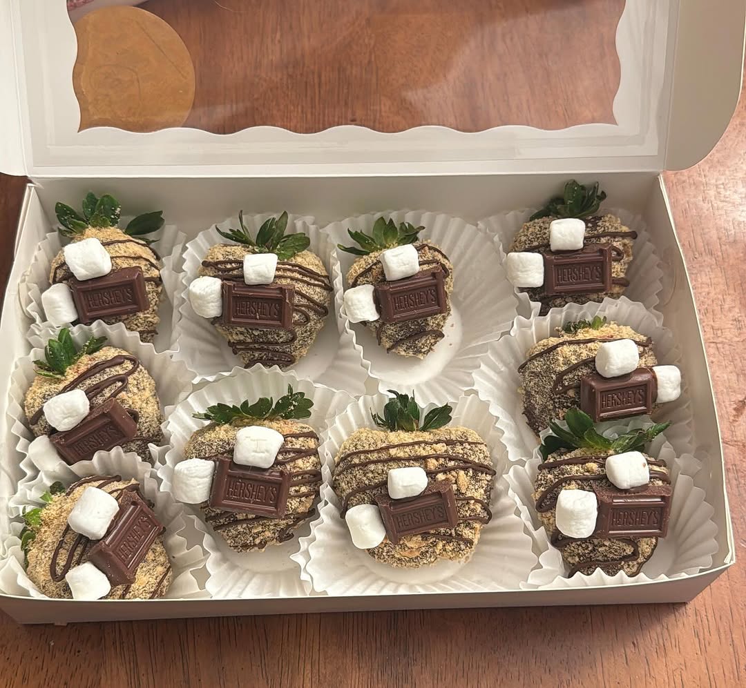 S'mores-themed strawberries coated in chocolate and rolled in graham cracker crumbs, topped with mini marshmallows and Hershey's bar pieces.