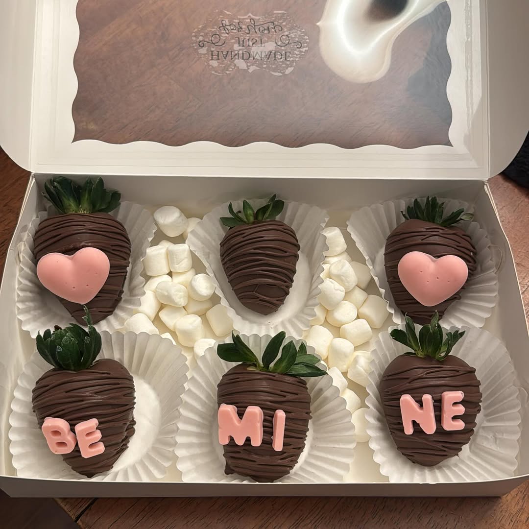 Valentine's Day six-pack of dark chocolate strawberries with BE MINE spelled in pink letters and pink heart decorations, accented with marshmallows.